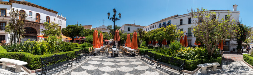 Fototapeta na wymiar Plaza de los Naranjos (Plaza of the Oranges) located in Marbella, Spain is plaza established in 1485 with restaurants, shops and a fountain surrounded by orange trees.