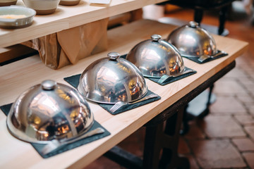 buffet in a restaurant or hotel. Metal dishes with caps.