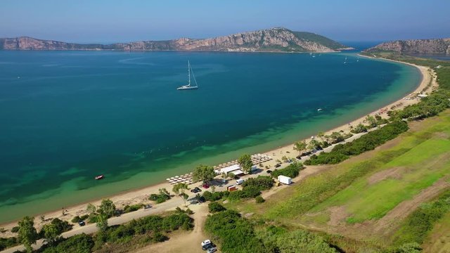 Aerial drone video from iconic sandy beach of Divari (chrysi akti) with emerald sea near island of Sfaktiria in bay of Navarino, Messinia, Gialova, Peloponnese, Greece
