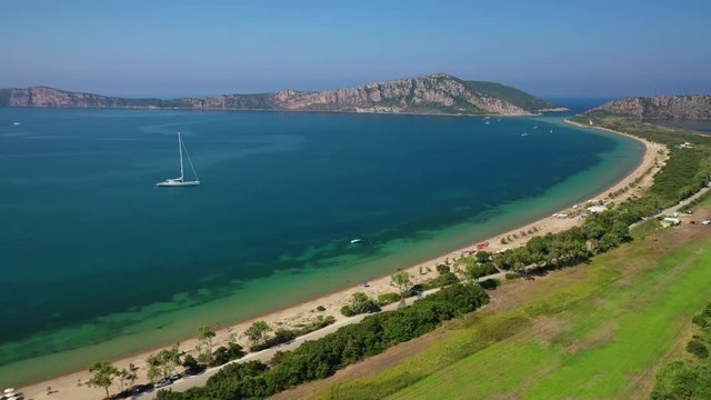Aerial drone video from iconic sandy beach of Divari (chrysi akti) with emerald sea near island of Sfaktiria in bay of Navarino, Messinia, Gialova, Peloponnese, Greece