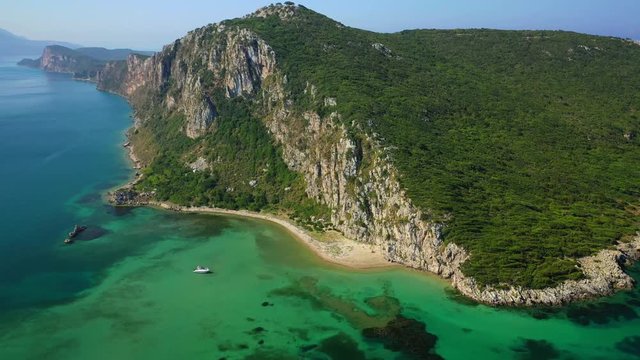 Aerial drone video of iconic secluded sandy beach with emerald sea in island of Sfaktiria next to bay and famous beach of Divari (chrysi akti), Messinia, Gialova, Peloponnese, Greece