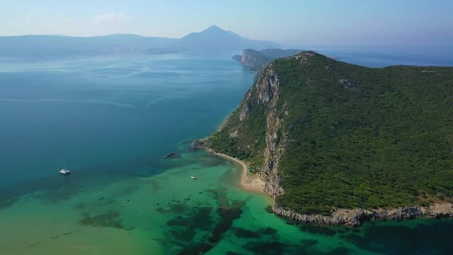 Aerial drone video of iconic secluded sandy beach with emerald sea in island of Sfaktiria next to bay and famous beach of Divari (chrysi akti), Messinia, Gialova, Peloponnese, Greece