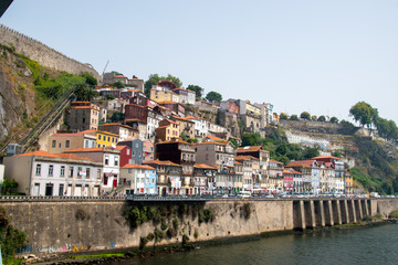 Fototapeta na wymiar Houses built on the side of a cliff with the funicular off the Douro river in Porto, Portugal