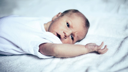 cute newborn baby lying on white blanket