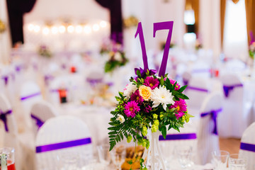 vase with flowers and number on the wedding reception at the res