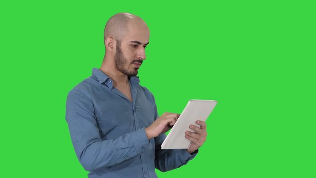 Handsome arabic business man using tablet on a Green Screen, Chroma Key.