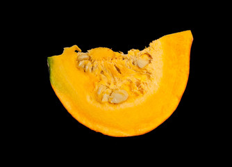 Pumpkin slice with seeds isolated on black background