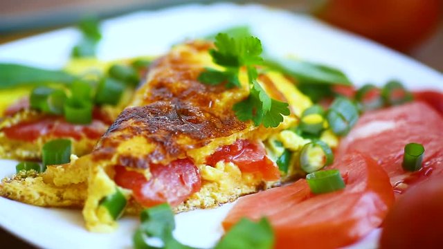 fried omelet from homemade organic eggs with tomatoes and green onions
