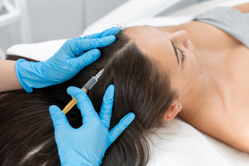 Beautician injections for healthy hair growth. Mesotherapy of the scalp. A young girl is undergoing a course of spa treatments in the office of a beautician. Moisturizing - obrazy, fototapety, plakaty