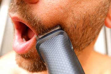 Hair clipper used to trim a man's beard with little money to save himself from going to the...