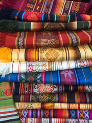 Large pile of typical colorful andean textiles found at the famous Otavalo market in Ecuador