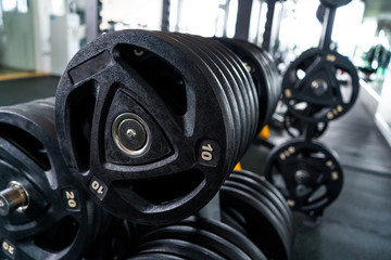 Obraz na płótnie Canvas Modern light gym. Sports equipment in gym. Barbells of different weight on rack.