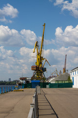 Northern river port with working cargo cranes on a clear summer day background of the river Moscow Russia
