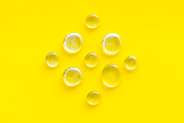 Glass stones for design and home creativity on yellow background top view