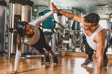 Couple training at gym, high five during pushups
