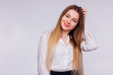 Fototapeta premium business woman in white blouse holds her hand in her hair and lo