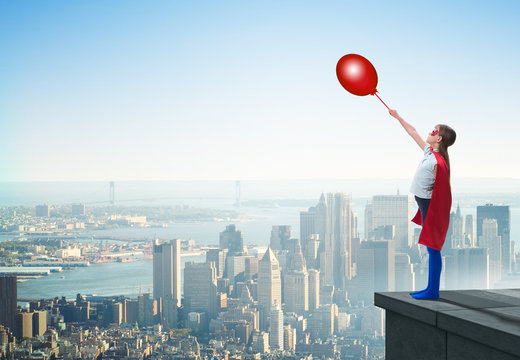 Young Girl In Superhero Costume Overlooking The City