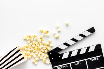 Movie premiere concept with clapperboard, popcorn on white background top view space for text