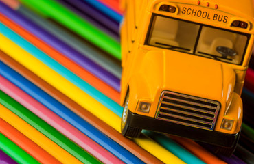 Color pencils on yellow school bus school supplies