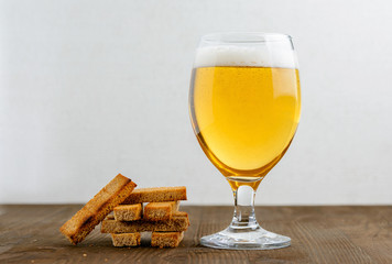 Glass of beer and snacks on a wooden table