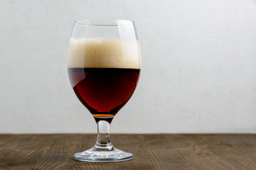 Glass of dark beer on a wooden table with copyspace