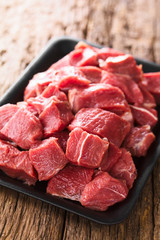 Fresh raw diced red beef meat on cast iron plate (Selective Focus, Focus one third into the meat)