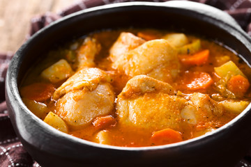 Fresh homemade chicken stew with potato, carrot and celery, seasoned with paprika in rustic bowl (Selective Focus, Focus one third into the image)