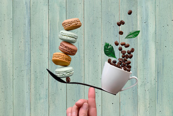 Balancing cup of coffee and macarons on a finger