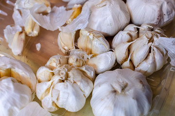 White garlic pile texture. Fresh garlic on market table closeup photo. Vitamin healthy food spice image. Spicy cooking ingredient picture. Pile of white garlic heads.
