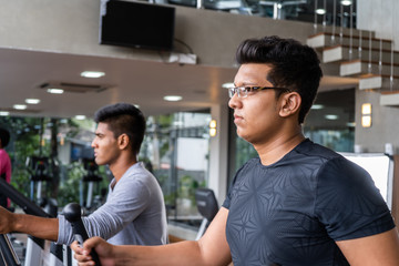 Athletic man on excersice bike at the gym