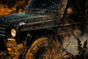 Bottom view to big offroad car wheel on country road and mountains backdrop. Off the road travel on...