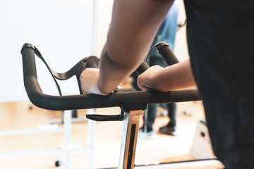 Fit people working out at spinning class in gym