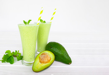 Avocado green smoothies colorful fruit juice milkshake blend beverage healthy high protein the taste yummy In glass,drink episode morning on white wooden background.
