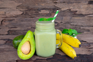Avocado with banana green smoothies colorful fruit juice milkshake blend beverage healthy high protein the taste yummy In glass drink episode morning on wooden background.