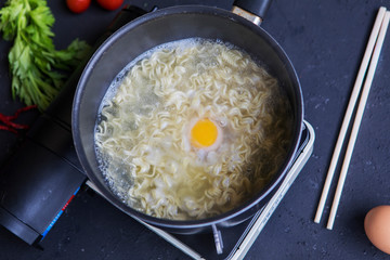 Noodles boiled with an egg in a pan