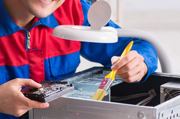 Professional repairman repairing computer in workshop