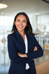 Confident cheerful young businesswoman. Professional business woman standing with crossed arms and...