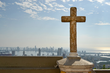 La Popa Convent`s Cross with the Cartagena City and Sea in the Background, warm tones coming from the sun beside the cross