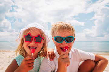 happy little girl and boy with lollipop on summer vacation