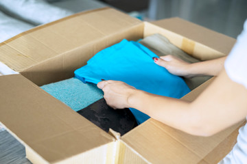 Woman putting old clothes in a cardboard box