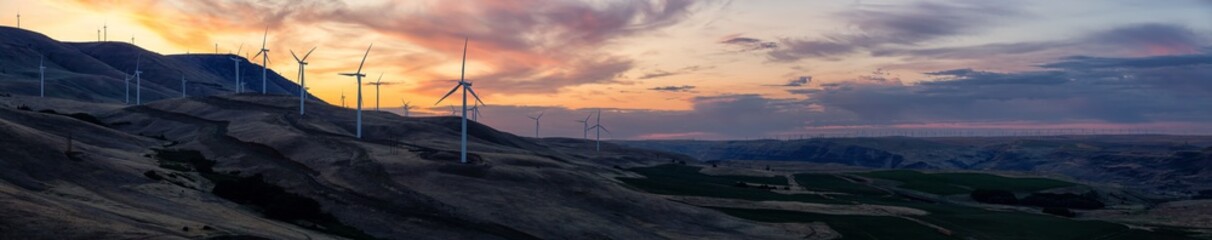 Naklejka na ściany i meble Beautiful Panoramic Landscape View of Wind Turbines on a Windy Hill during a colorful sunrise. Taken in Washington State, United States of America.