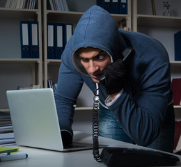 Young hacker hacking into computer at night