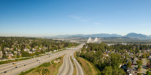 Fototapeta na wymiar Aerial panoramic view of Trans Canada Highway near the Port Mann Bridge during a sunny morning. Taken in Surrey, Vancouver, BC, Canada.