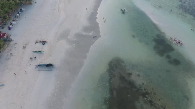 Drone shot of the beautiful Paradise Beach coastline in Bantayan Philippines with baroto boats on the shore
