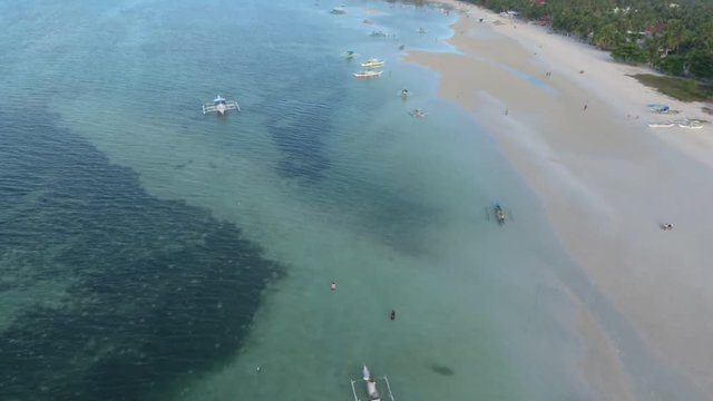 Drone shot of the beautiful Paradise Beach coastline in Bantayan Philippines with Baroto boats on the shore