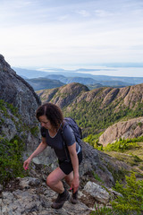 Adventurous girl hiking the beautiful trail in the Canadian Mountain Landscape during a vibrant summer evening. Taken at Mt Arrowsmith, near Nanaimo, Vancouver Island, BC, Canada.