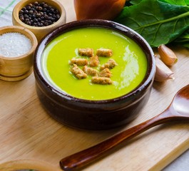 Spinach soup served on wooden board