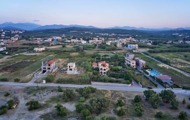 Fototapeta premium Aerial view on Platanias beachfront area with villas and road at evening time. Crete, Greece.