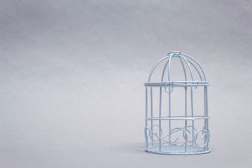 Fototapeta na wymiar Closed decorative bird cage on a light background.