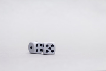 Two square cubes for gambling dice on a light background.